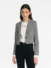 a lady in check cropped jacket with white t-shirt and black jeans